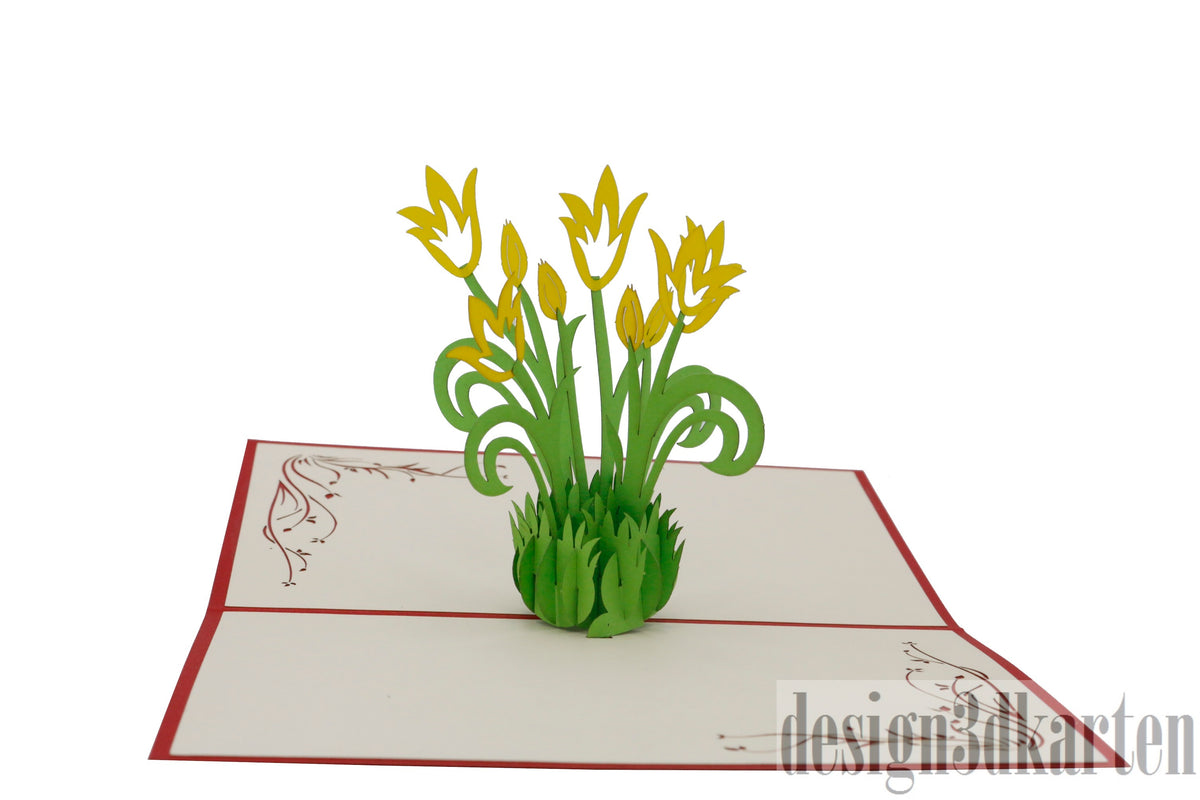 Aufgeklappte Pop-up-Karte mit gelben Tulpen aus Papier, schräg von der Seite fotografiert.